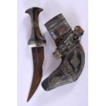AN ANTIQUE OMANI MIDDLE EASTERN CARVED RHINOCEROS HORN JAMBIYA DAGGER with hide and white metal