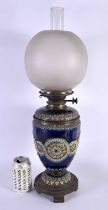A LARGE ANTIQUE DOULTON STONEWARE OIL LAMP decorated with flowers and motifs. 54 cm x 12 cm.