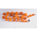 AN AMBER TYPE NECKLACE. 25 grams. 49 cm long, largest bead 2 cm x 1 cm.