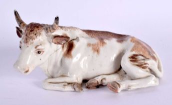 A RARE 18TH CENTURY AUSTRIAN VIENNA PORCELAIN FIGURE OF A COW modelled recumbent. 12 cm x 5 cm.