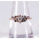 A 9CT GOLD AND DIAMOND CLUSTER RING. 2 grams. M.