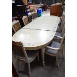 A hand painted extending dining table with 8 bergère style upholstered chairs previously in