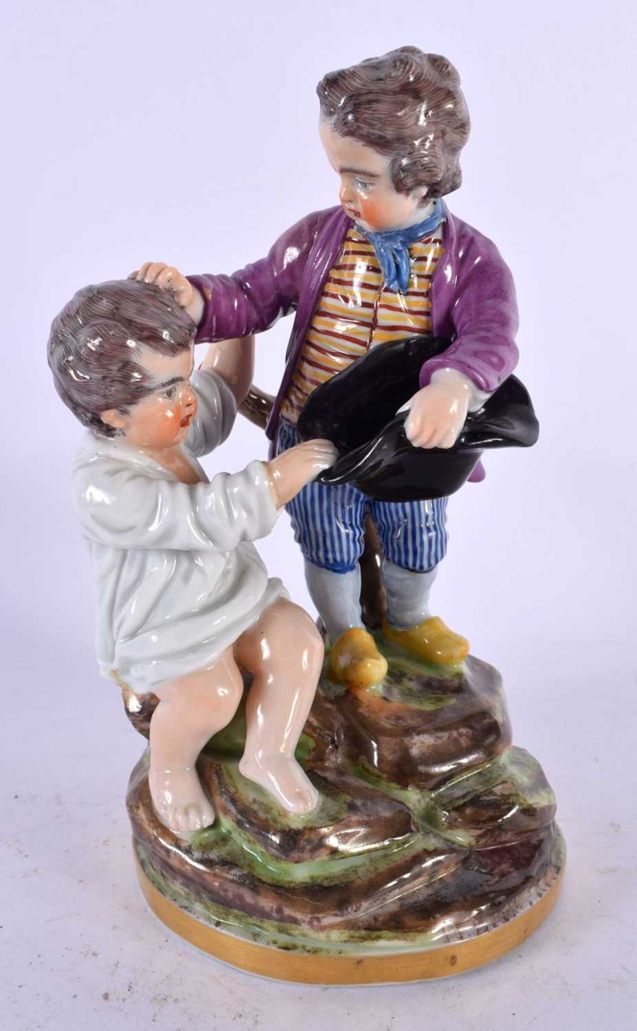 A 19TH CENTURY CONTINENTAL PORCELAIN FIGURE OF TWO BOYS modelled fighting over a hat. 18 cm x 10