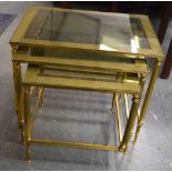 A NEST OF THREE MID CENTURY BRASS GLASS TOPPED TABLES. Largest 52 cm x 36 cm. (3)