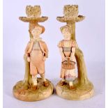 A PAIR OF 19TH CENTURY ROYAL WORCESTER BLUSH IVORY CANDLESTICKS formed as figures. 20 cm high.