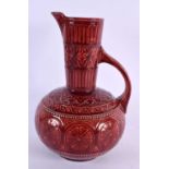 AN ARTS AND CRAFTS RED POTTERY JUG Attributed to Dr Christopher Dresser. 25 cm x 13 cm.