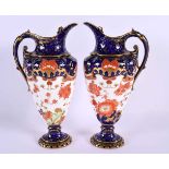 A PAIR OF ROYAL CROWN DERBY PORCELAIN EWERS painted with flowers. 22 cm high.