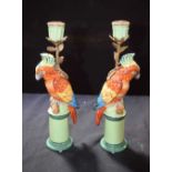 A PAIR OF PARROT PORCELAIN CANDLESTICKS. 30 cm high.