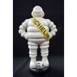 A CAST IRON MICHELIN MAN ON TYRE. 39 cm high.