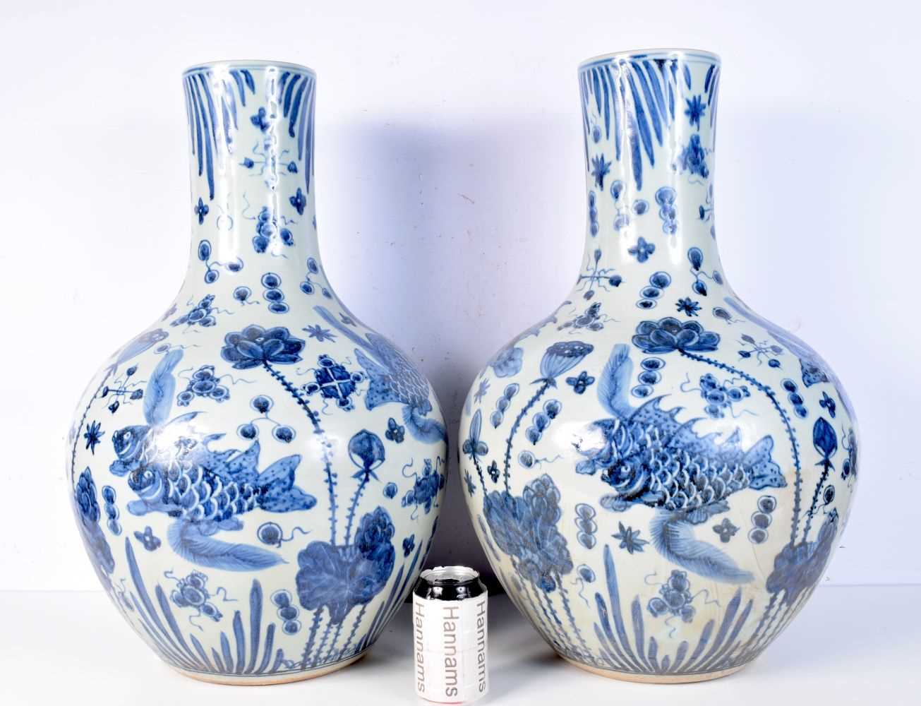 A large pair of blue and white porcelain vases decorated with fish. 59cm (2).