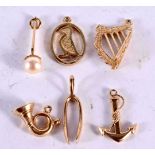 SIX 9CT GOLD CHARMS MODELLED AS A WISHBONE, A HARP, A FRENCH HORN, AN ANCHOR, A PEARL DROP AND A