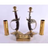 A PAIR OF CANDLESTICKS IN THE FORM OF SWORD HANDLES TOGETHER WITH A PAIR OF SECOND WORLD WAR SHELL