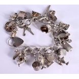 A STERLING SILVER CHARM BRACELET WITH 23 ASSORTED CHARMS. Total weight 112g