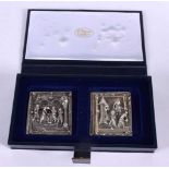 A CASED SET OF TWO WHITE METAL PLAQUES DEPICTING SCENES FROM THE BRONZE DOOR OF THE BASILICA OF