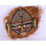 AN AFRICAN TRIBAL BEADWORK AND CONCH SHELL TRIBAL MASK. 24 cm wide.