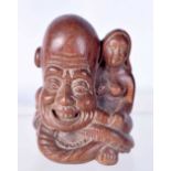 A JAPANESE CARVED WOOD NETSUKE IN THE FORM OF A GOD SITTING NEXT TO A NUDE WOMAN 5.4cm x 3.7cm x 3.