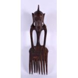 AN UNUSUAL EARLY 20TH CENTURY TRIBAL CARVED WOOD COMB formed as a stylised beast. 30 cm x 8 cm.