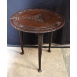 A small early 20th Century carved oak drop leaf cricket table with swivelling top