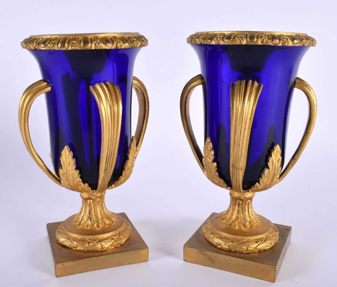 A LOVELY PAIR OF EARLY 19TH CENTURY FRENCH BLUE GLASS EMPIRE ORMOLU VASES modelled upon acanthus