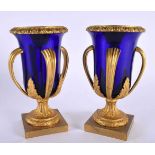 A LOVELY PAIR OF EARLY 19TH CENTURY FRENCH BLUE GLASS EMPIRE ORMOLU VASES modelled upon acanthus