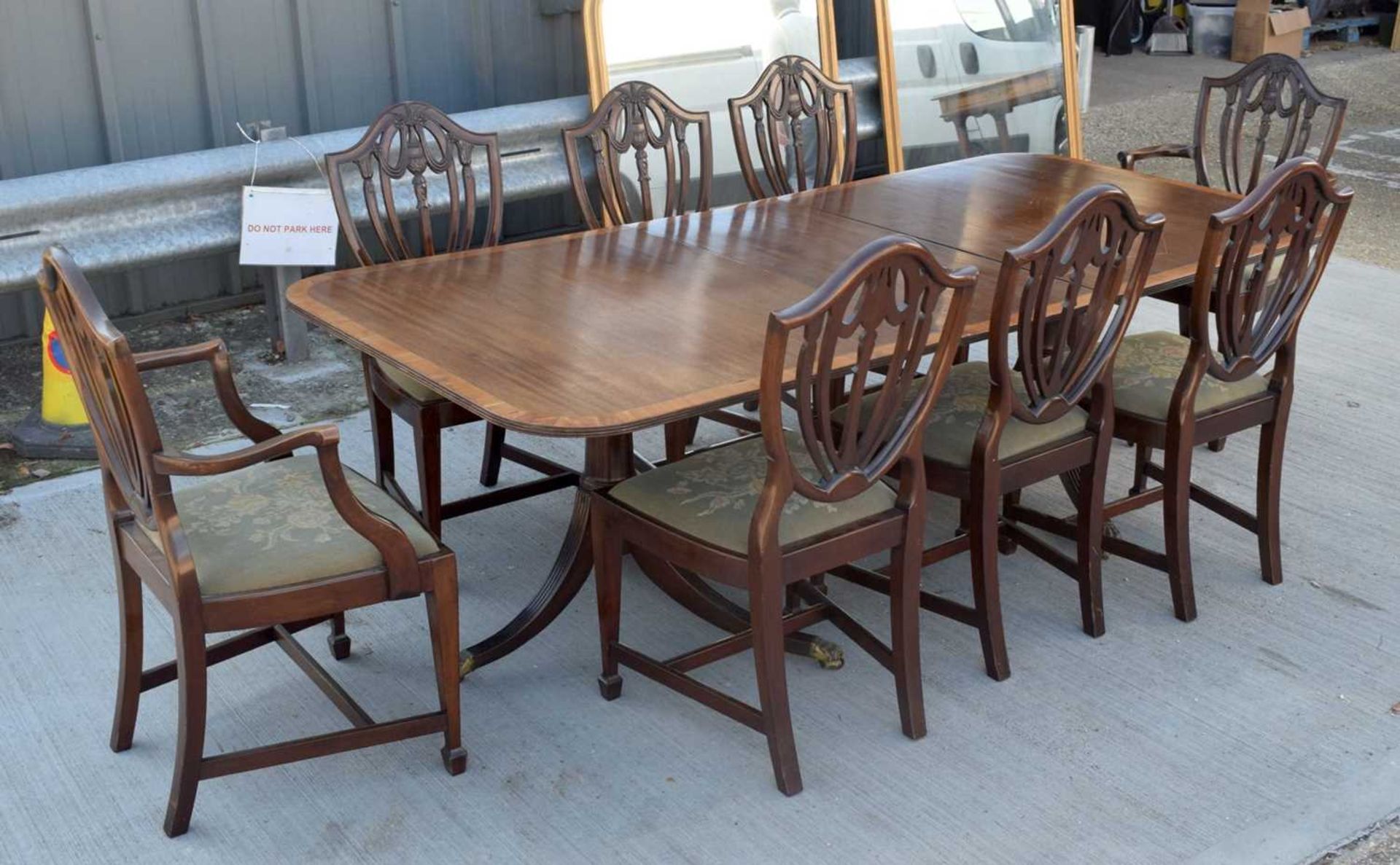 A Mahogany dining table with a veneer edging with 8 mahogany Shield back chairs with upholstered