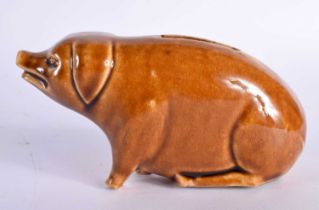 A SMALL TREACLE GLAZED PIG POTTERY MONEY BOX. 13 cm x 8 cm.