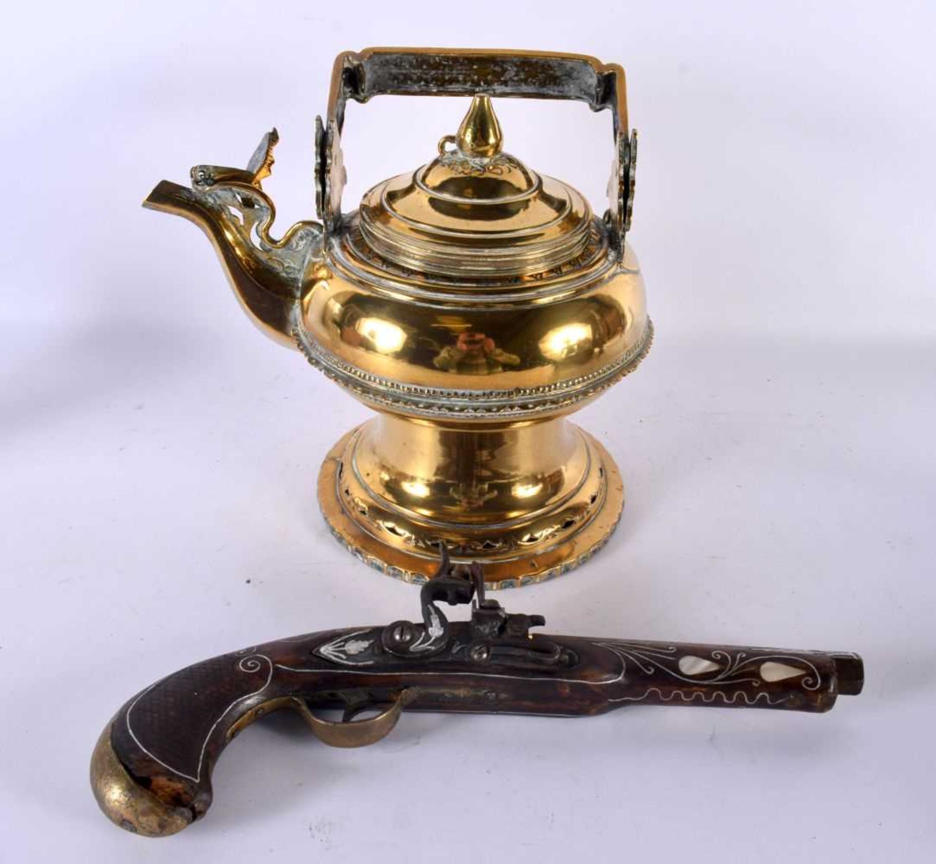 A TURKISH MOTHER OF PEARL INLAID PISTOL together with a Middle Eastern bronze teapot and cover.