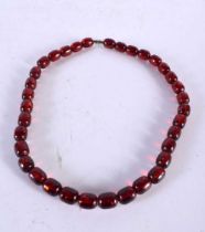 A CHERRY AMBER TYPE BEAD NECKLACE. 53 grams. 68 cm long.