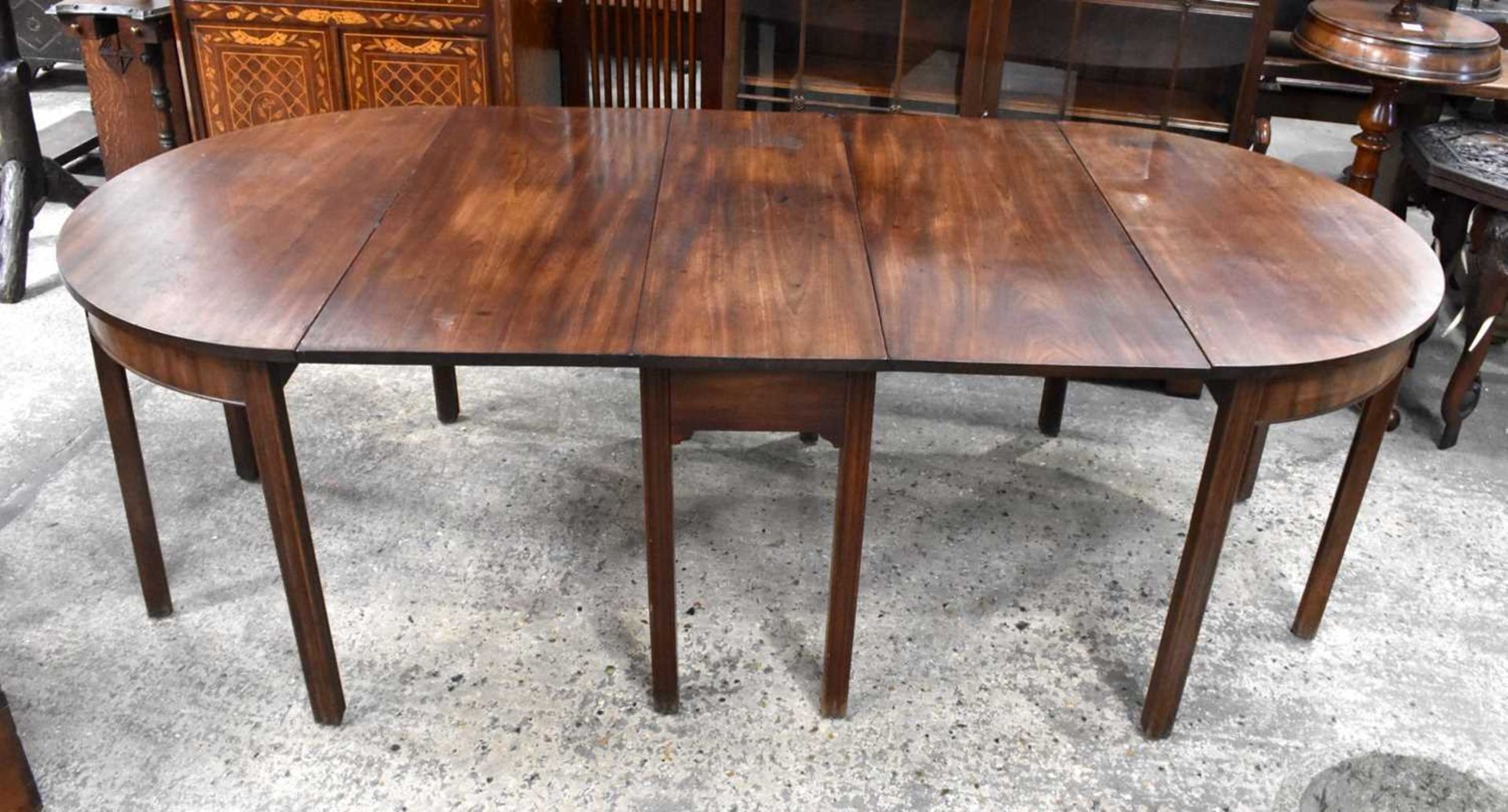 A Mahogany Dining table comprising of a central drop leaf table and two Demilune shaped extensions