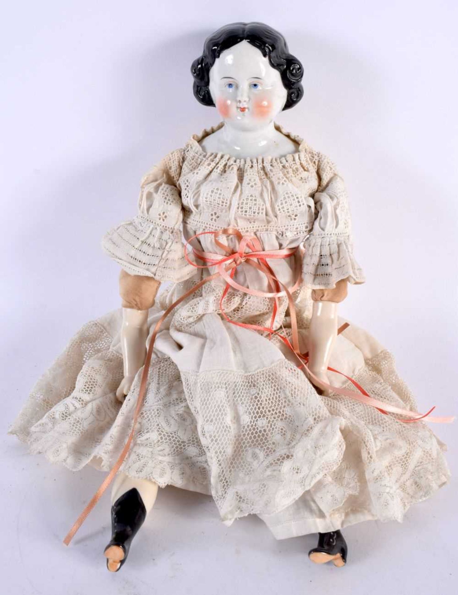 AN ANTIQUE PORCELAIN HEADED DOLL with lace outfit. 38 cm long.