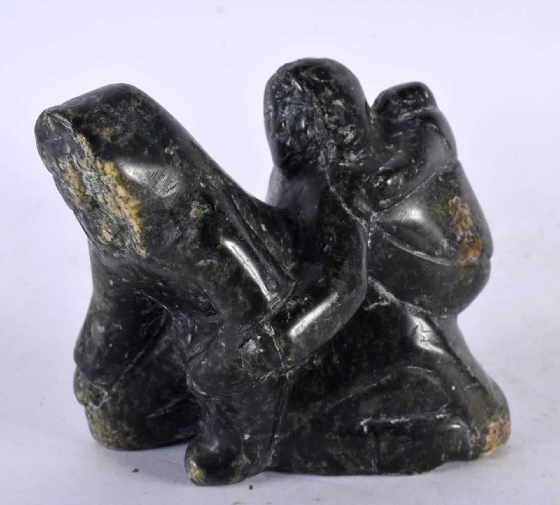 A NORTH AMERICAN INUIT TRIBAL CARVED STONE FIGURE OF A FAMILY. 9 cm x 8 cm.