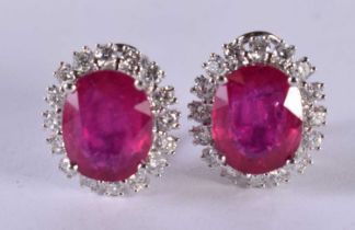 A PAIR OF 14CT WHITE GOLD EARRINGS SET WITH A RUBY SURROUNDED BY A DIAMOND BEZEL. STAMPED 14k 585,