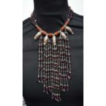 A beaded necklace with metal leaf decoration . 40 cm