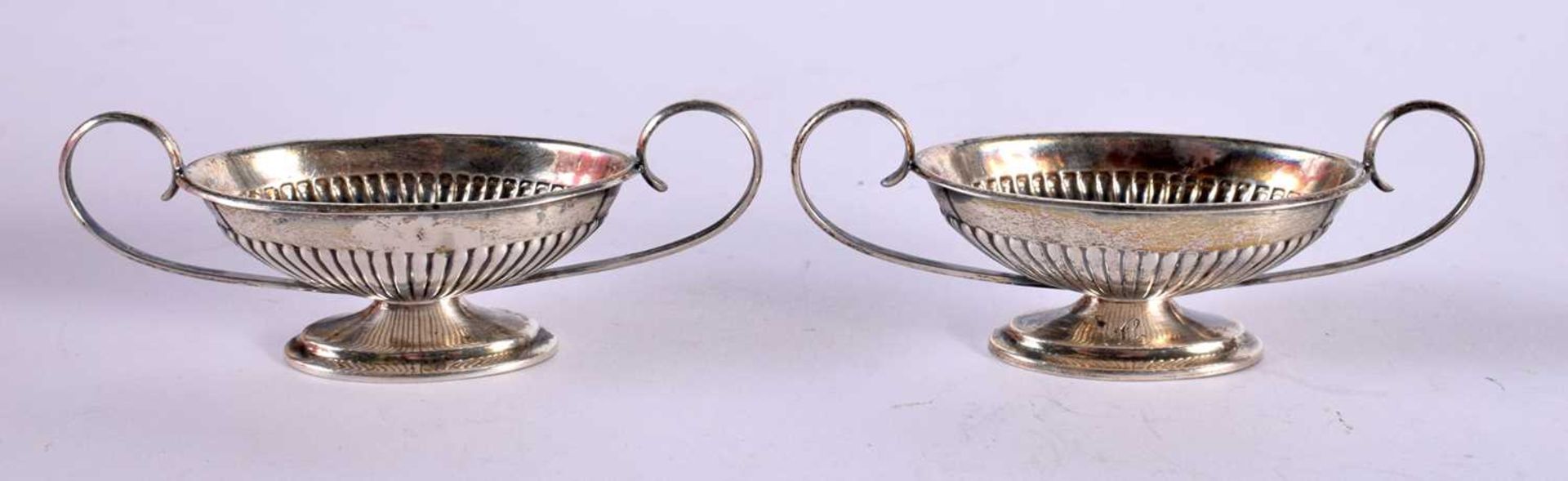 A PAIR OF SILVER CLASSICAL STYLE BOAT SHAPED SALTS. Stamped Sterling, 7.6 cm x 2.6 cm x 3cm, total