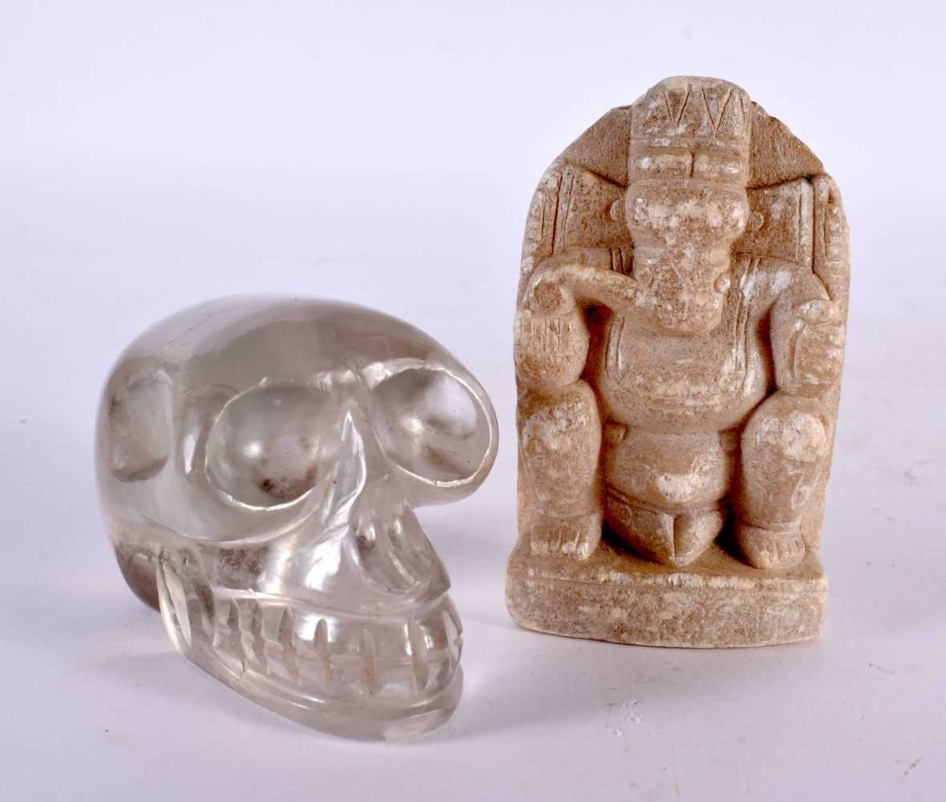 A LATE 19TH CENTURY INDIAN CARVED STONE FIGURE OF GANESHA together with a carved rock crystal skull.