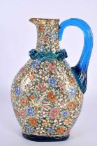 AN ART NOUVEAU ENAMELLED BLUE GLASS AESTHETIC JUG decorated in relief with birds amongst foliage. 19