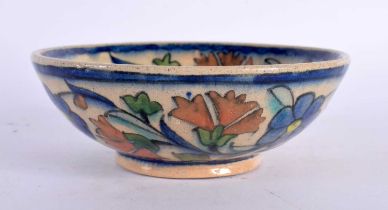 A MIDDLE EASTERN FAIENCE IZNIK TYPE POTTERY DISH painted with flowers. 12 cm diameter.