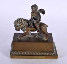 A LOVELY EARLY 19TH CENTURY ENGLISH REGENCY BRONZE INKWELL depicting a winged boy riding upon a