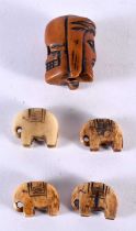 AN UNUSUAL ANTIQUE CARVED MEMENTO MORI NUT TOGGLE together with four carved bone tribal elephant