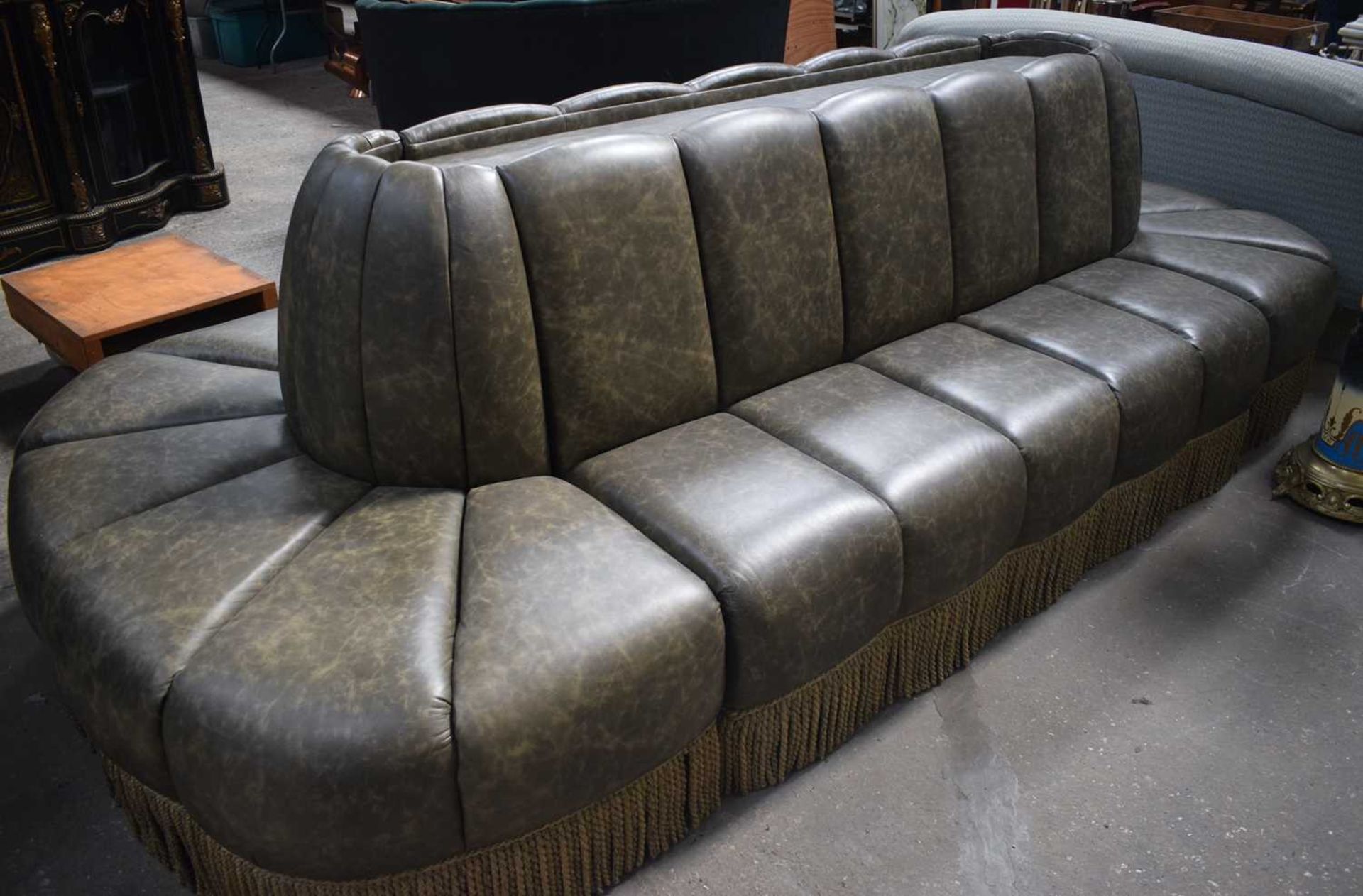 A large Oval Faux leather inter connecting Gallery Sofas with a central wooden panelled insert