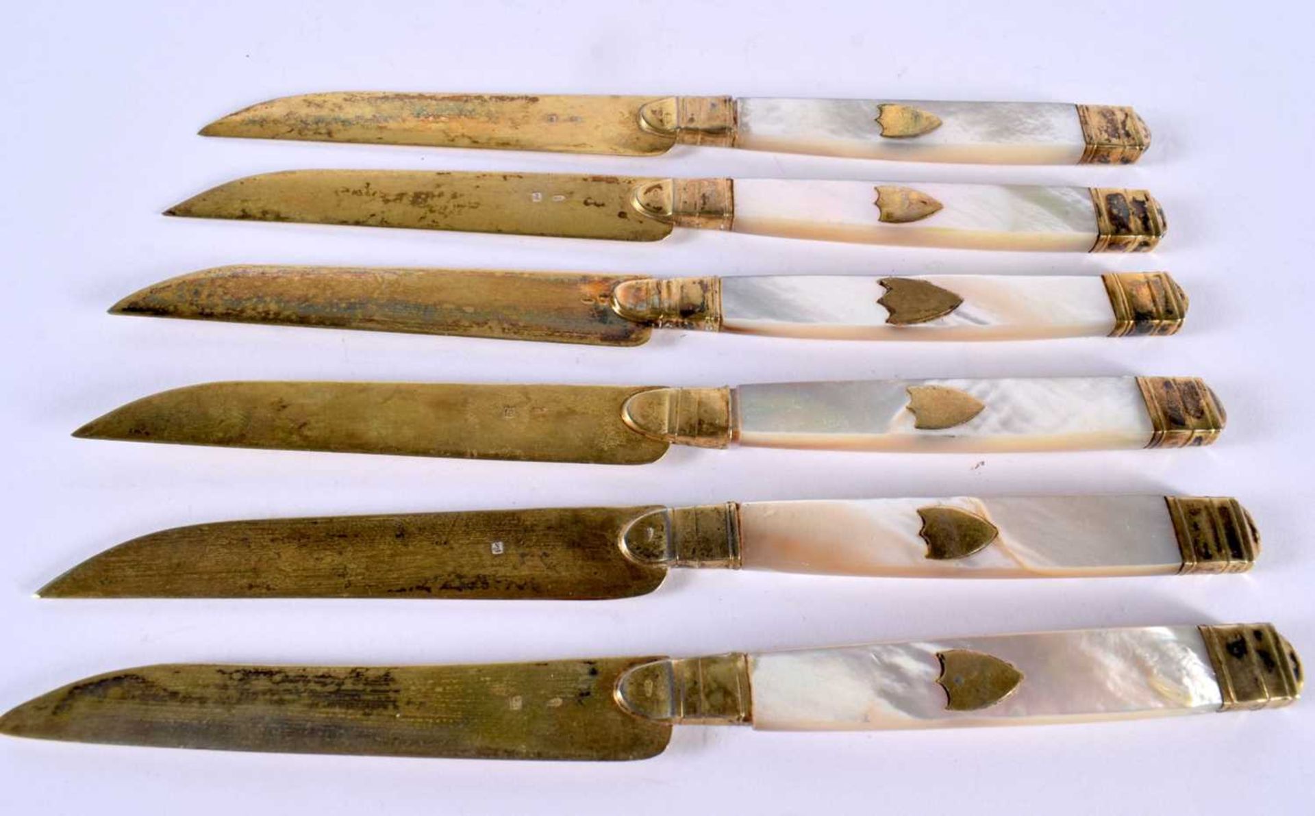 A SET OF SIX ANTIQUE SILVER GILT AND MOTHER OF PEARL KNIVES. 203 grams. 20cm long. (6)