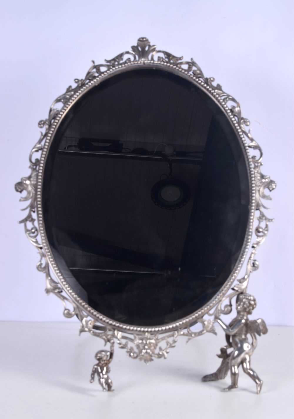 A large dressing table bevelled mirror plated metal with scrolling surround with Cherub supports