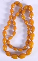 AN AMBER TYPE NECKLACE. 57.4 grams. 76 cm long.