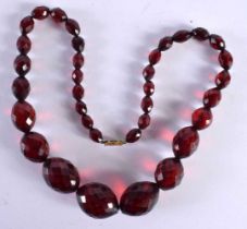 AN ART DECO RED CHERRY AMBER TYPE FACETTED NECKLACE. 49 grams. 52 cm long.