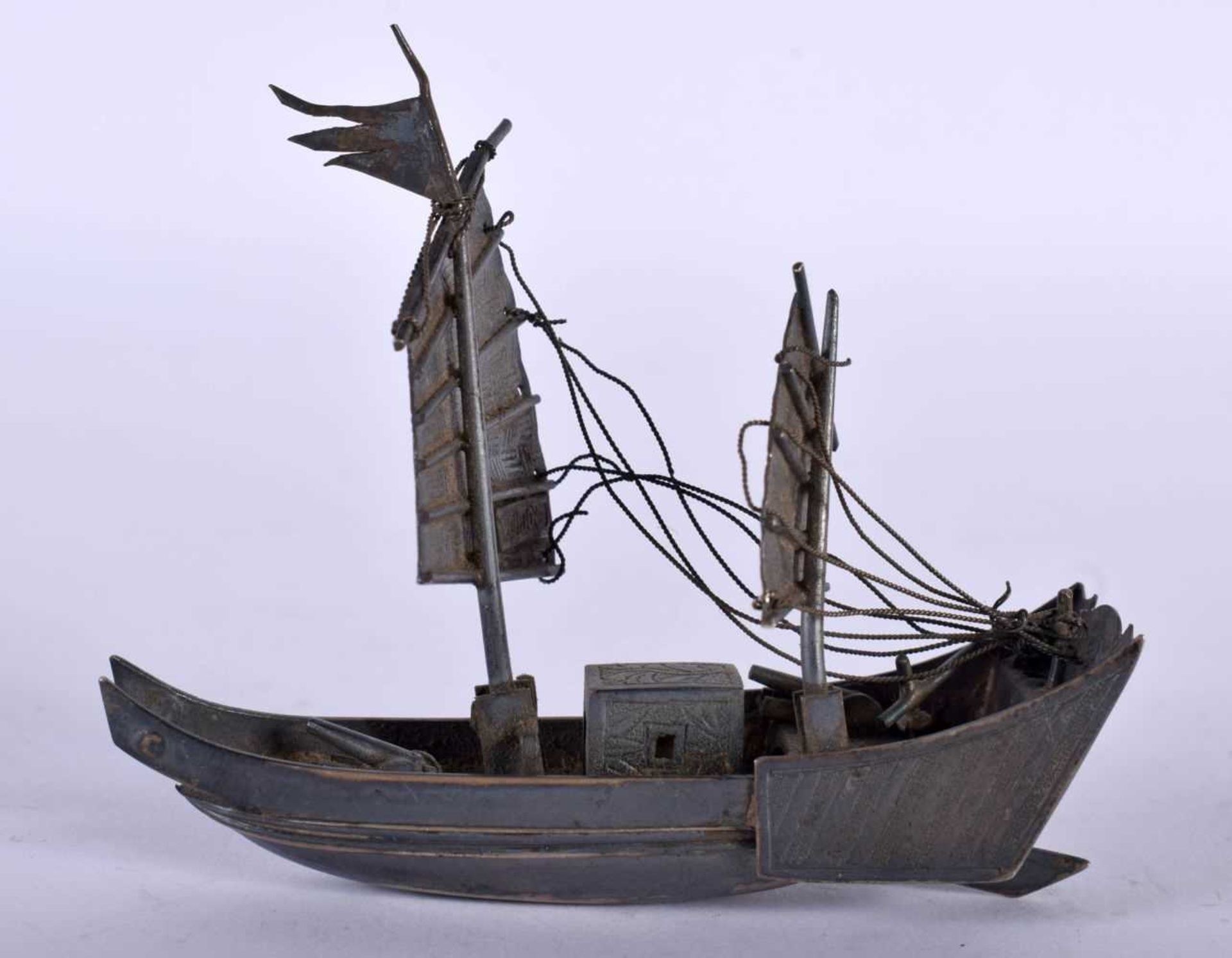 A Chinese White Metal Model of a Junk. 7.1cm x 6.1cm x 2.4cm, weight 26g. Damage to rigging