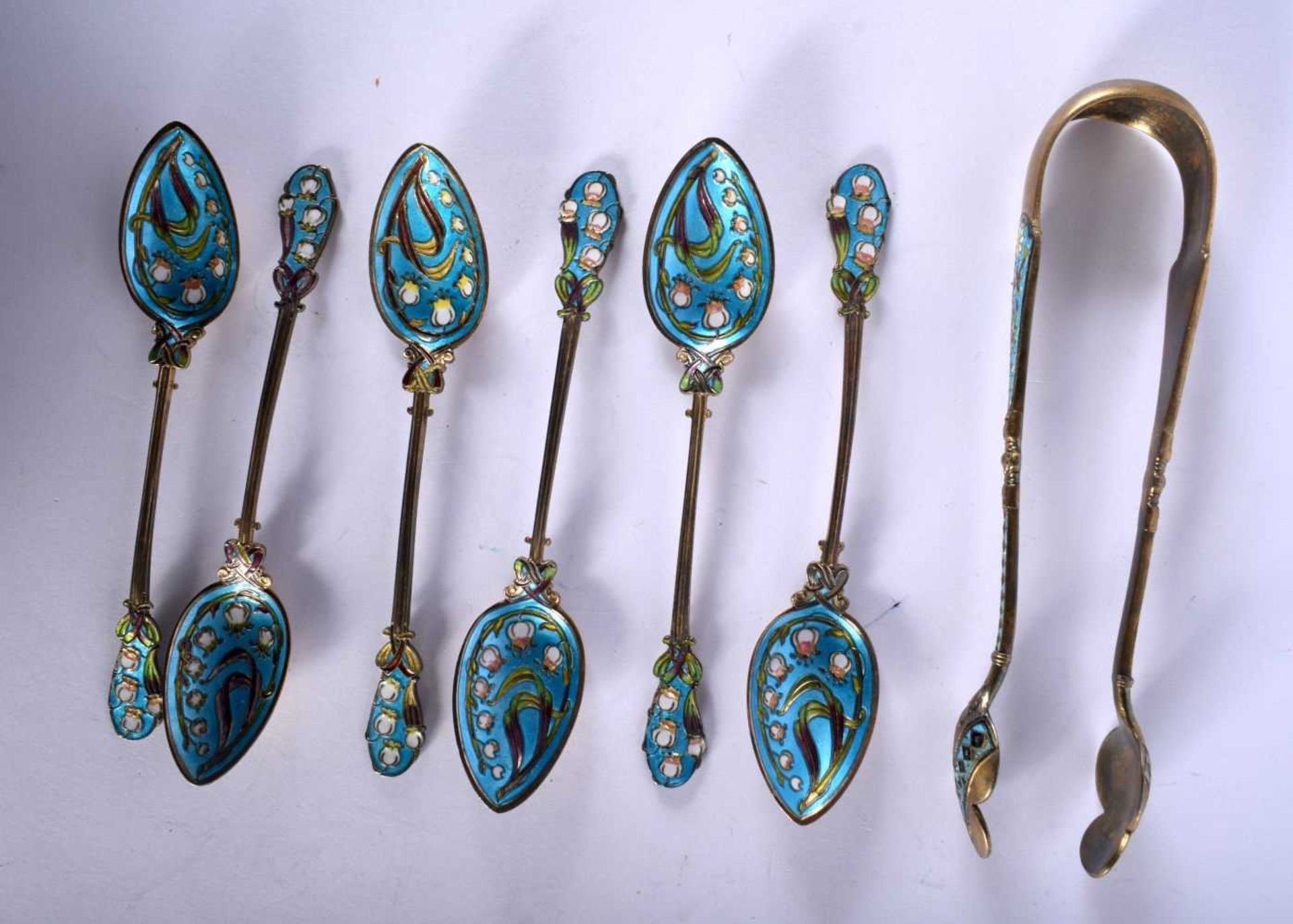Set of Six Silver and Enamel Gilt Teaspoons together with a similar pair of Sugar Tongs. Stamped