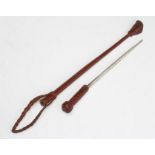 A SWORD STICK/CROP with 10 1/2" blade and braided leather shaft, handle and strap, 20 1/2" long (