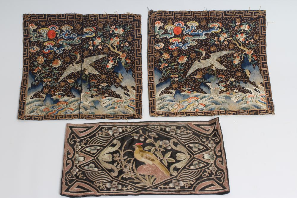 A PAIR OF CHINESE SILK SQUARE PANELS embroidered in coloured silks on a dark navy ground