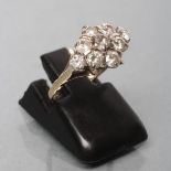 A NINE STONE DIAMOND CLUSTER RING, the old cut stones claw set to a plain shank, size J (Est. plus