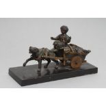 A BRONZED AND PARCEL GILT INKWELL,19th century, modelled as a boy riding a dog cart of vegetables,